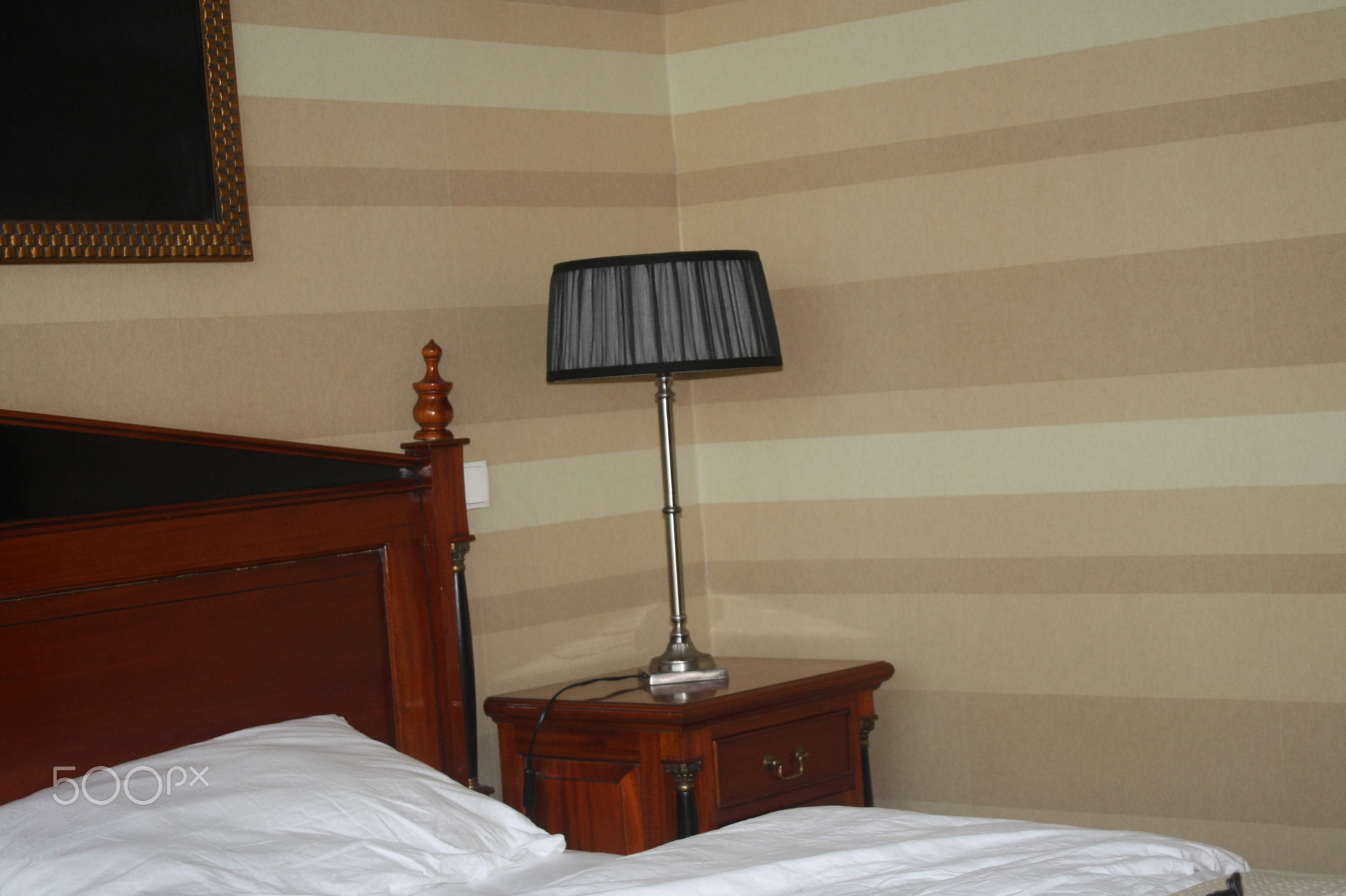 A bedroom with a bed and the lamp