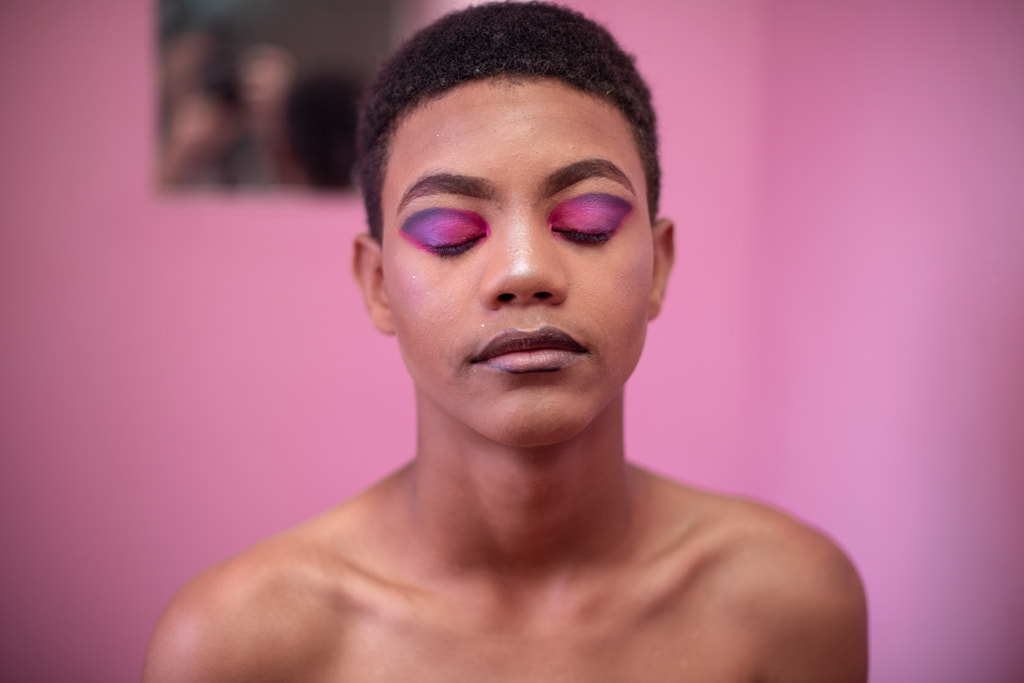 Close up portrait of young queer person against pink background by Rushay Booysen on 500px.com