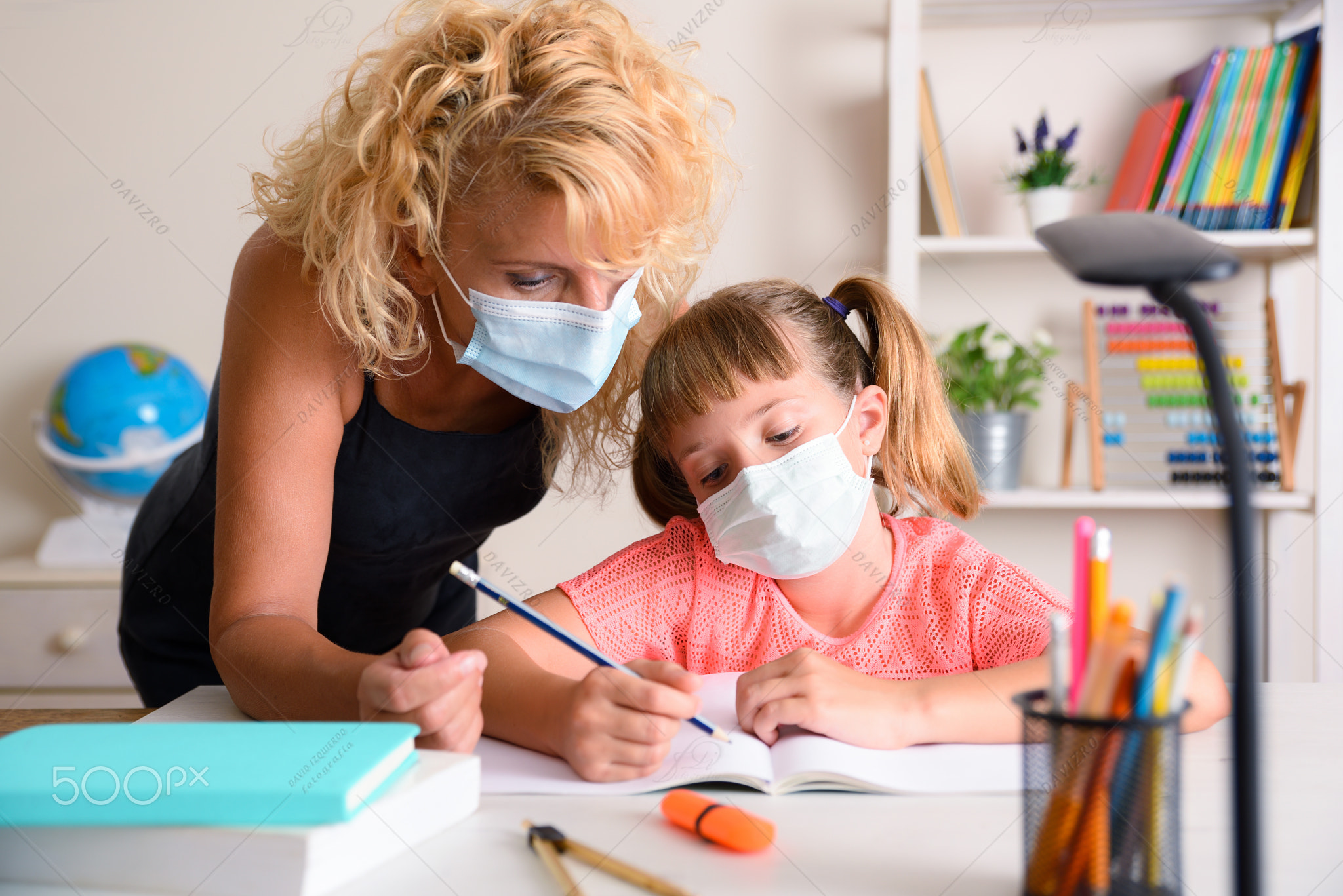 Mother explaining lesson to daughter confined at home
