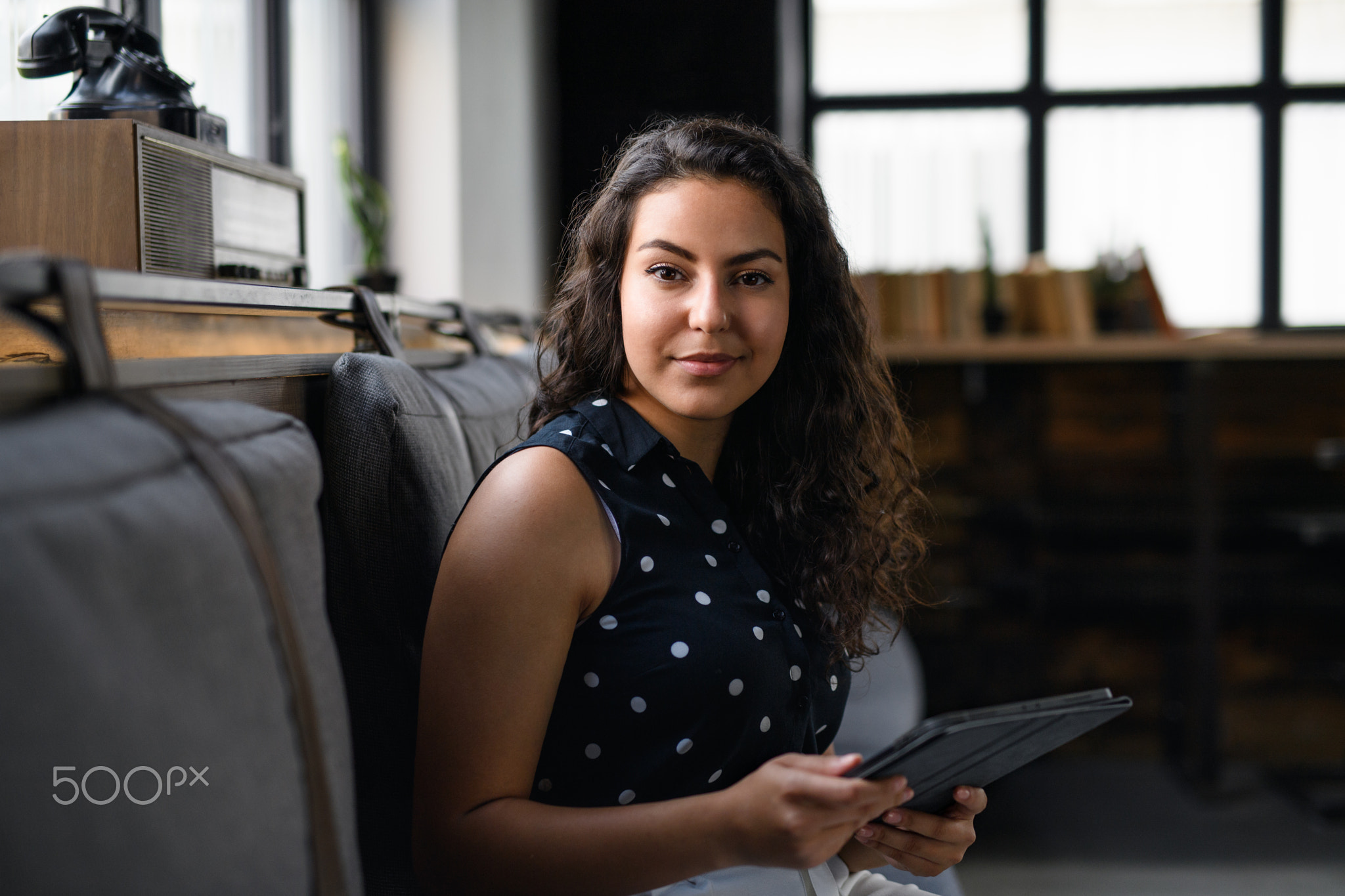 Portrait of young businesswoman indoors in office, looking at camera.