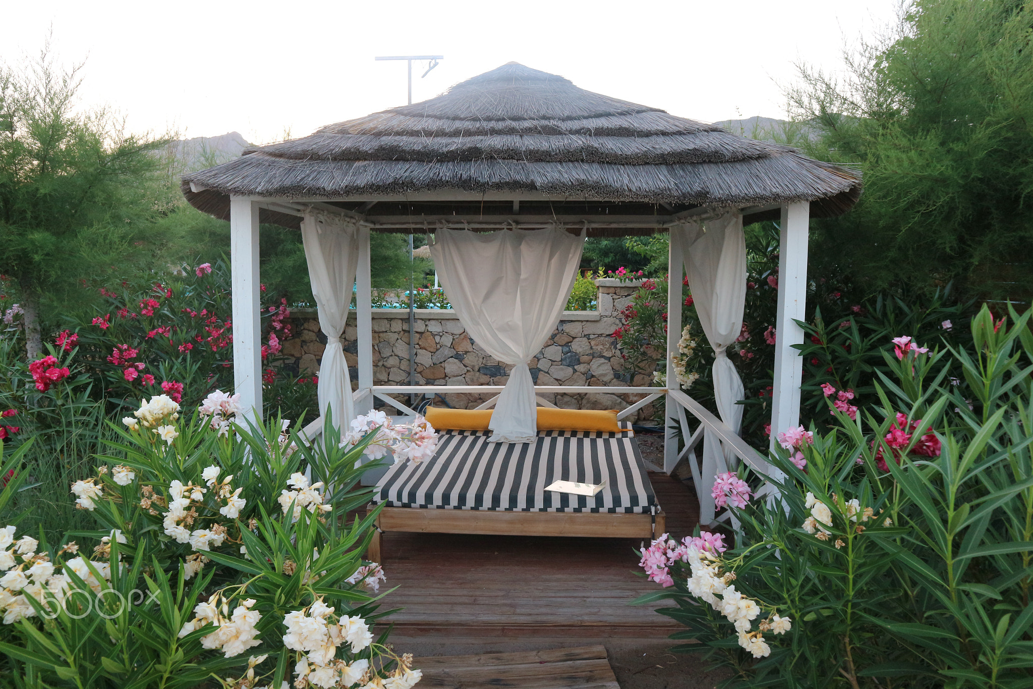 Day Bed in Greece with White Curtains Tied Back