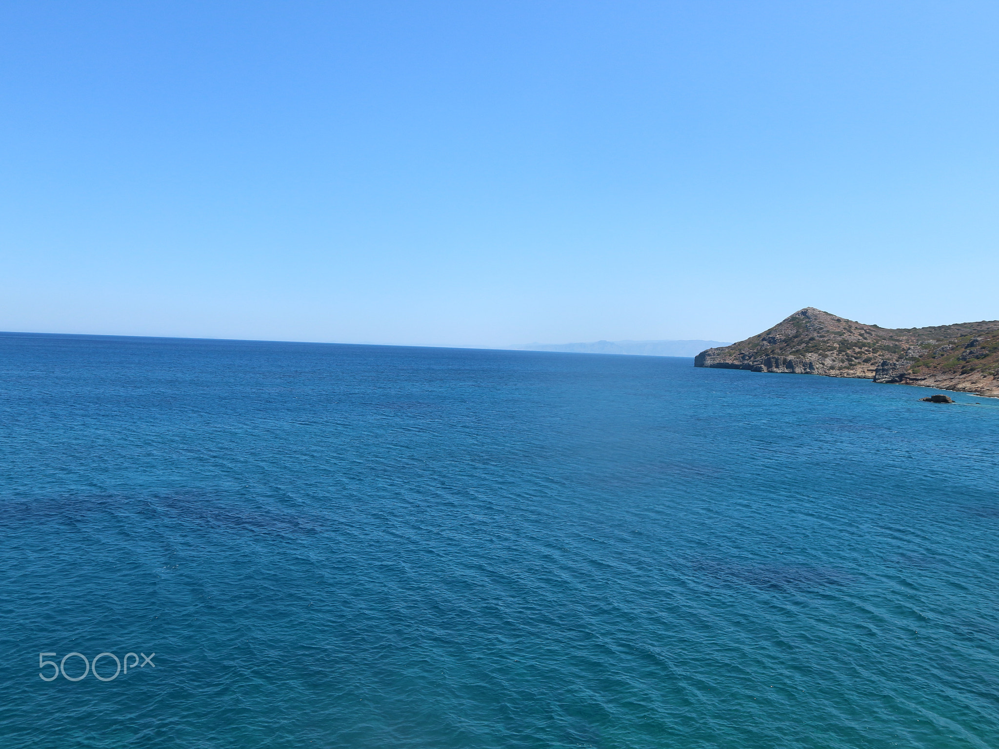 Dark Blue Still Ocean with Ripples and Bright Light Blue Sky