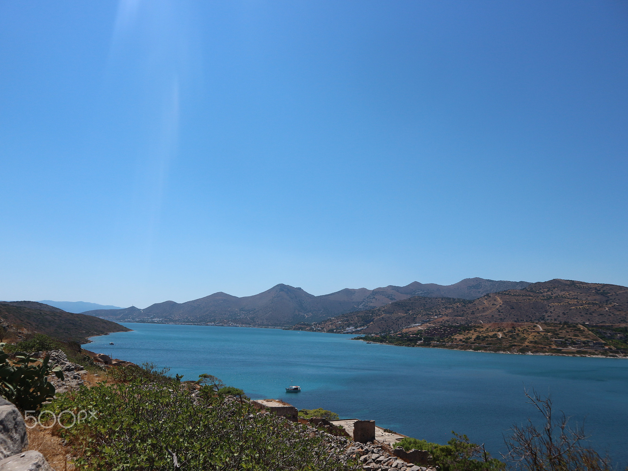 Blue Ocean Which Looks Like A River with Mountains in the Background