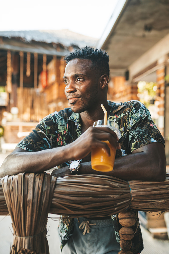 Portrait of african american man drinking mango shake in outdoor cafe by Natalie Zotova on 500px.com