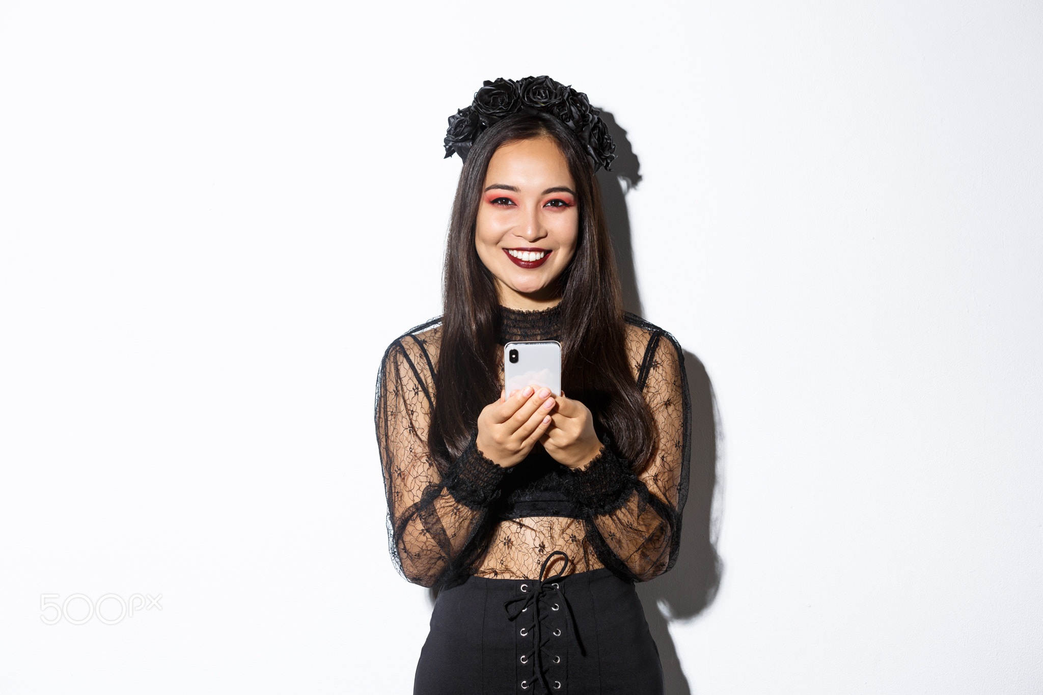 Image of elegant pretty brunette witch in gothic lace dress using
