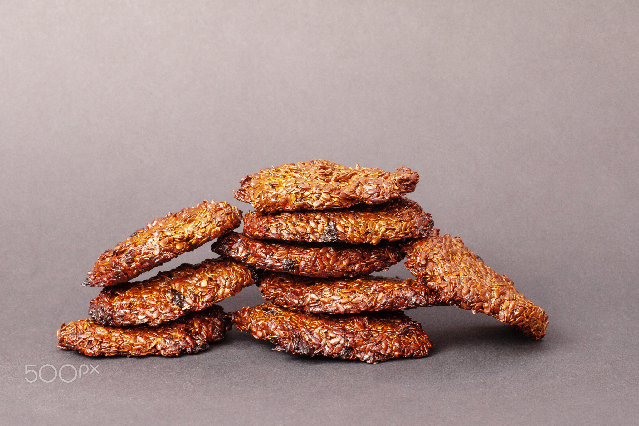 A pile of oatmeal cookies on a gray background.