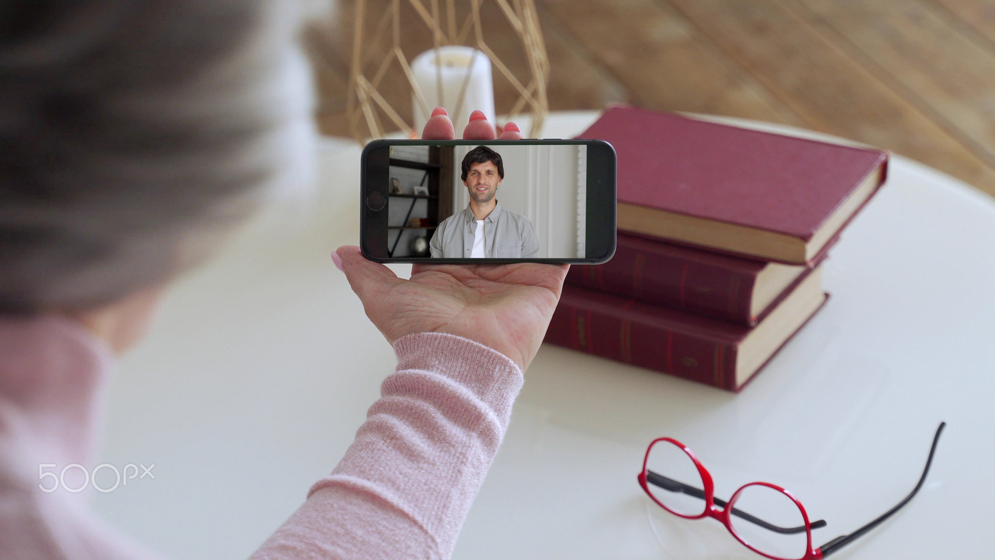 Over the shoulder view of an elderly woman video call to a young son