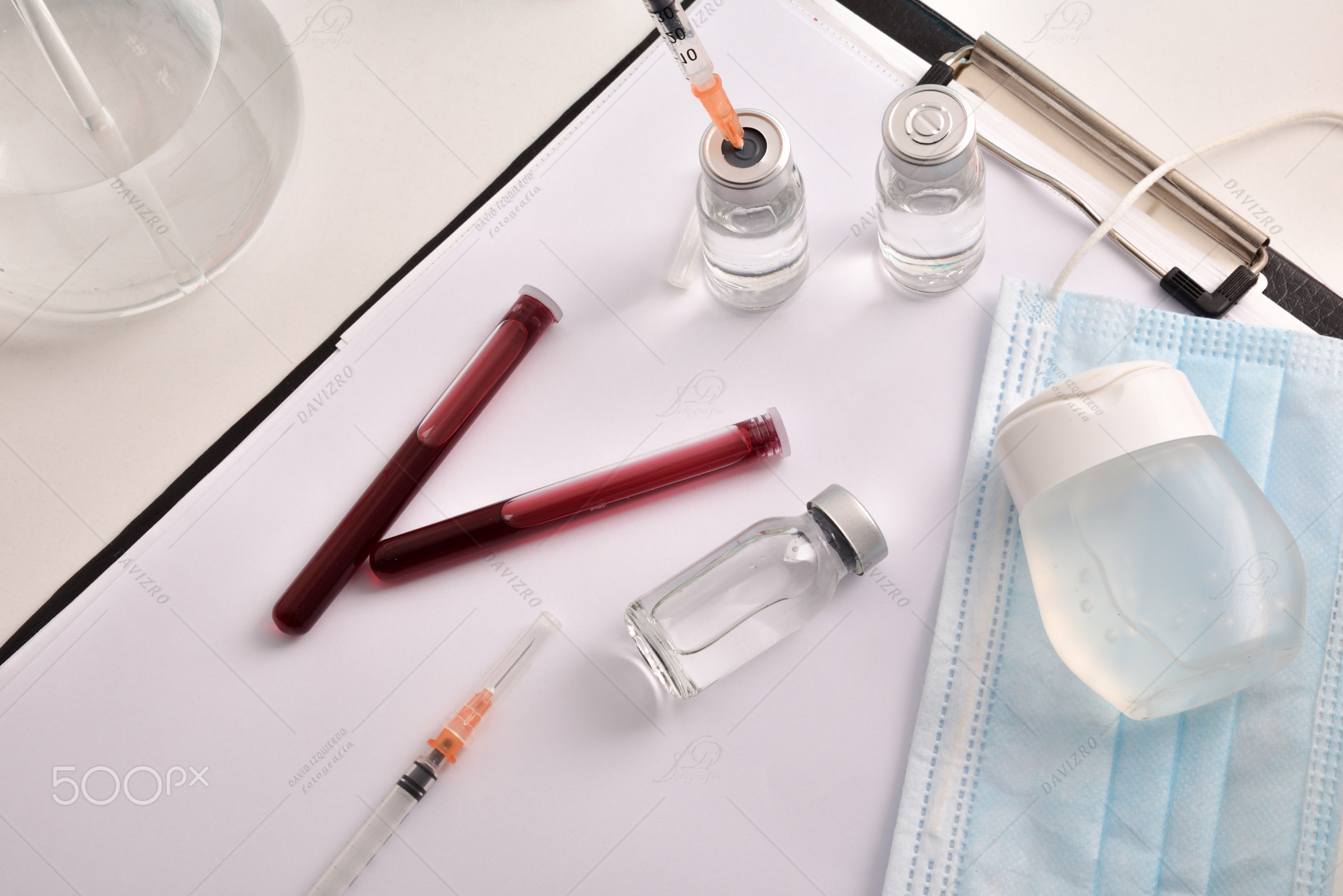 Blood samples vaccines and personal protection on folder in lab