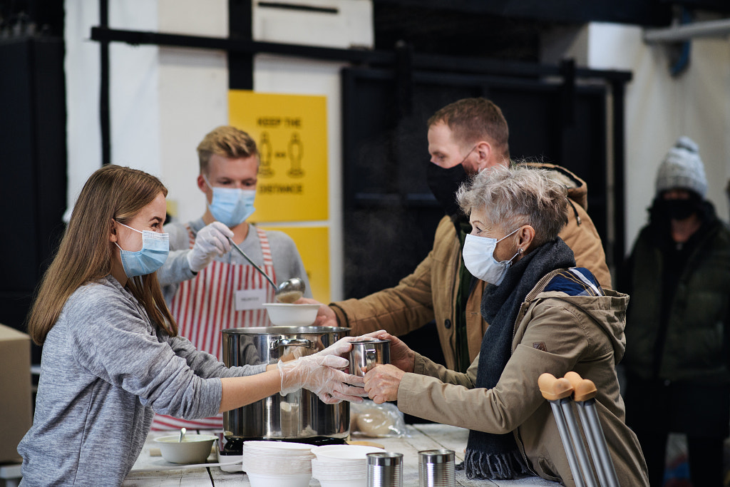 Volunteers serving hot soup for homeless in community charity donation by Jozef Polc on 500px.com