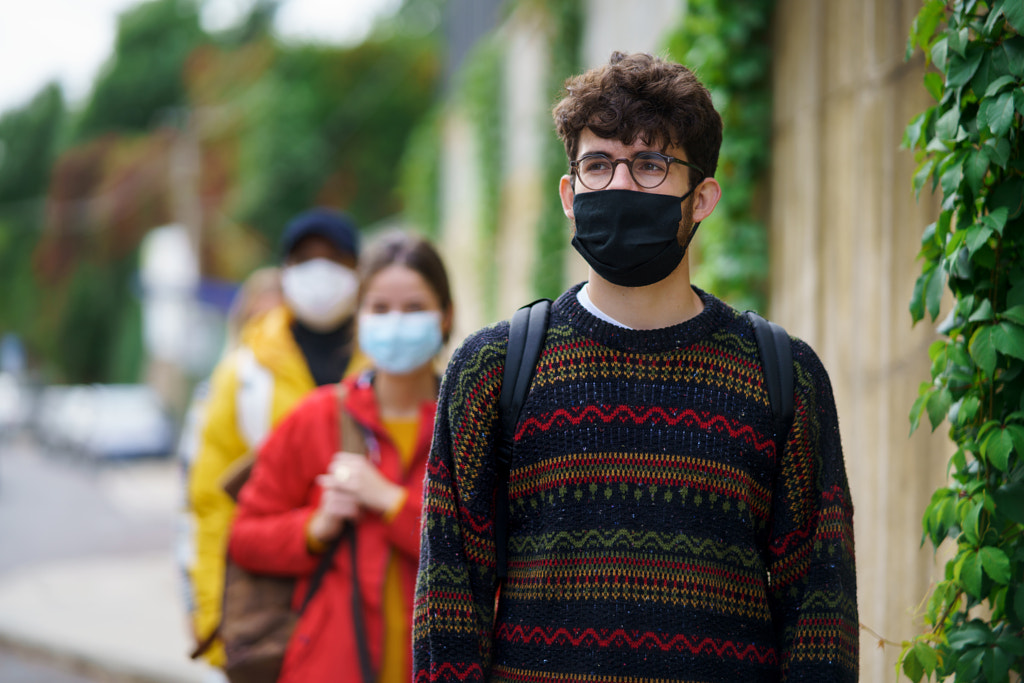 Young people standing outdoors in town. Coronavirus and safe distance by Jozef Polc on 500px.com