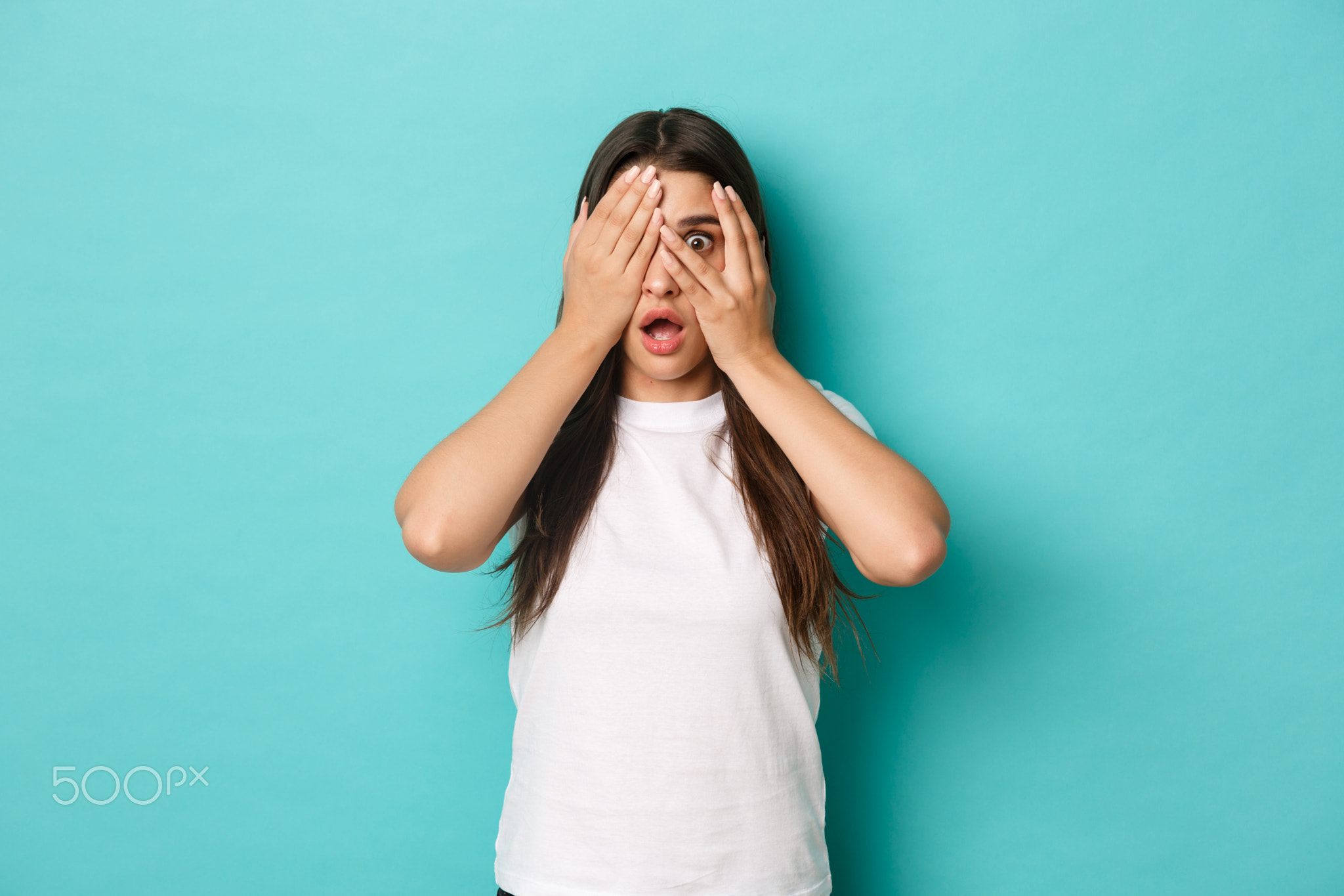Image of shocked and scared brunette woman in white t-shirt, shut eyes