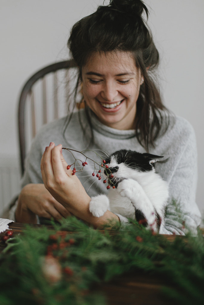 Cute cat helping young woman making rustic christmas wreath by Bogdan Sonjachnyj on 500px.com