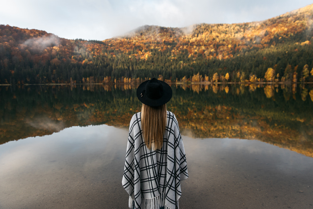 Young woman wearing hat and poncho in autumnal forest lake by Szabo  Ervin-Edward on 500px.com