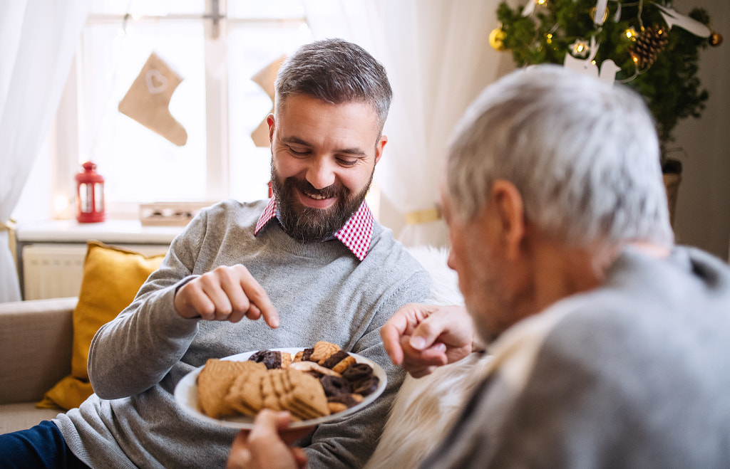 Mature man and senior father indoors at home at Christmas, eating by Jozef Polc on 500px.com