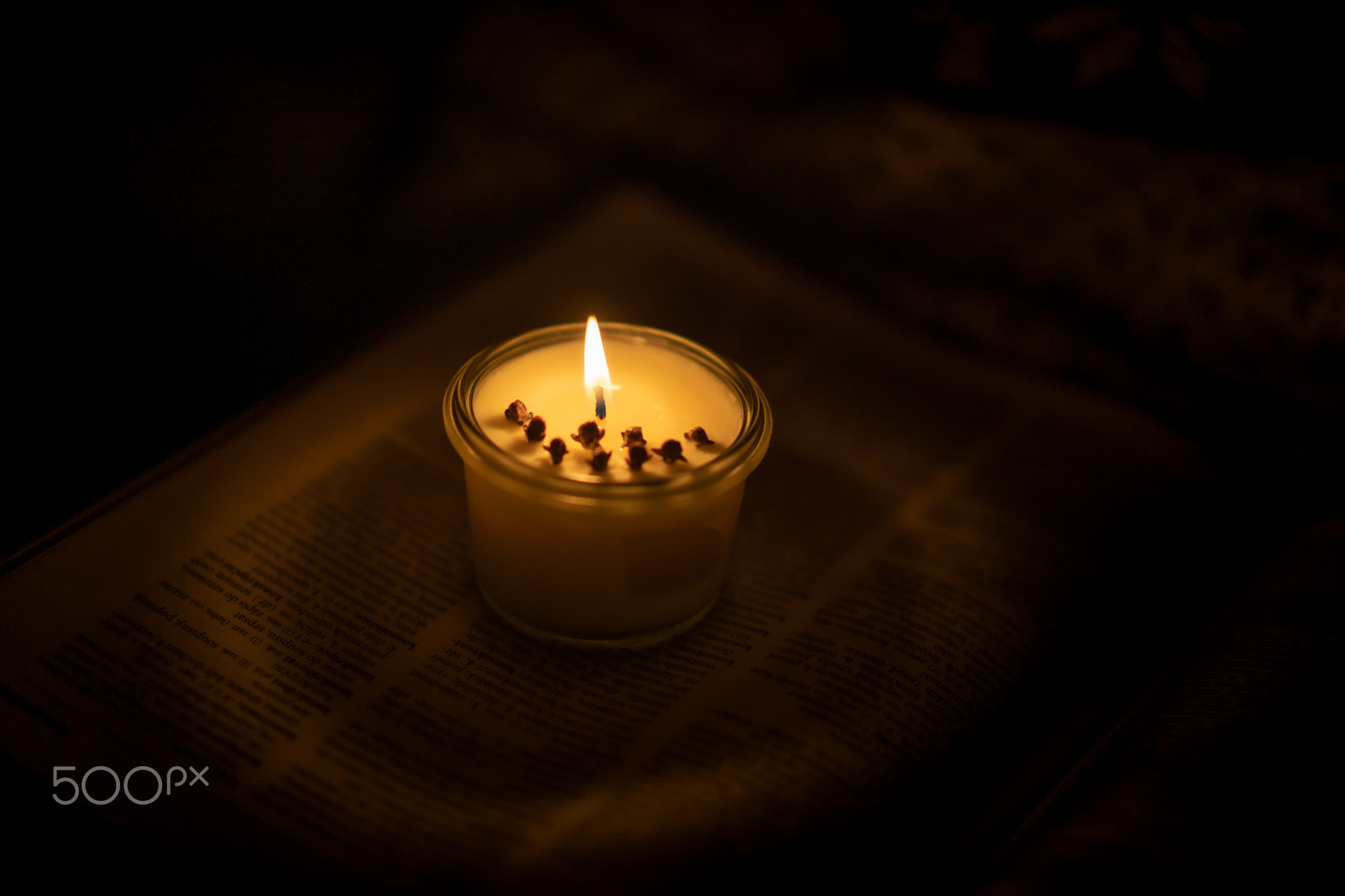 Soy candle lights old book in the library