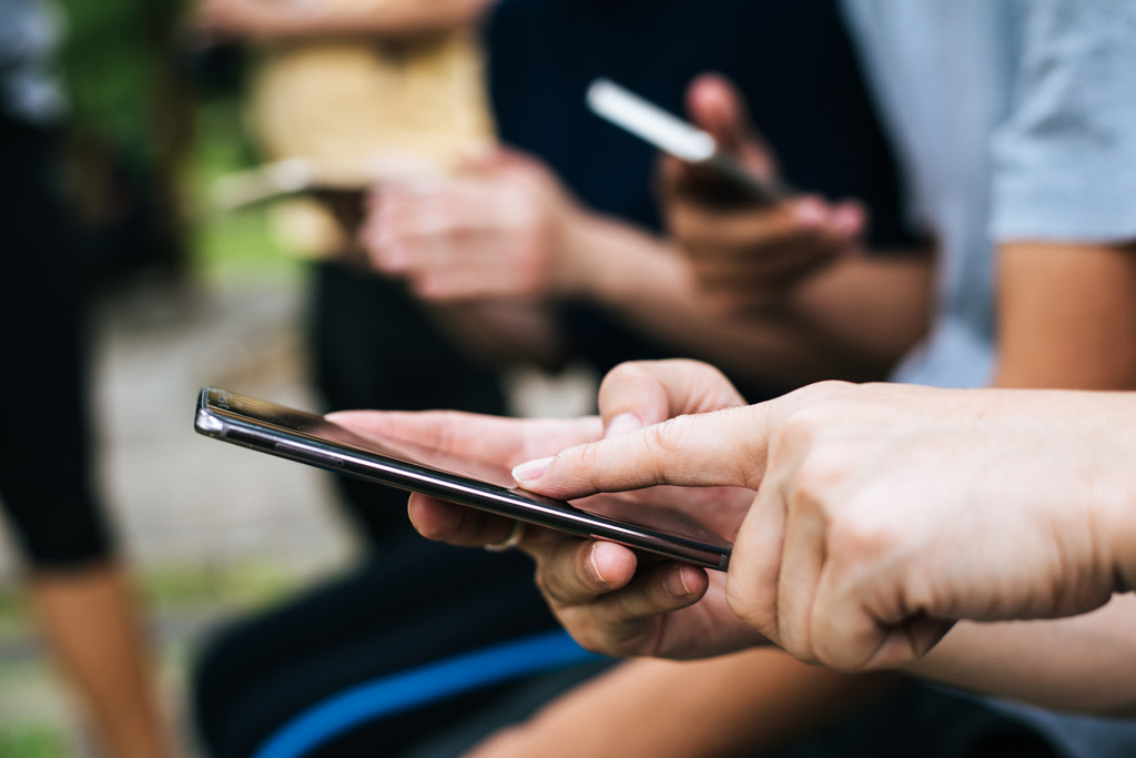 Close up of friends hands play with smartphone together. by Prakasit Khuansuwan on 500px.com