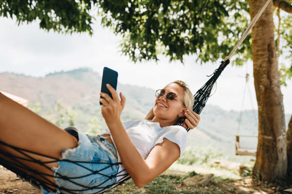 Woman is laying in hammock and using phone by Natalie Zotova on 500px.com