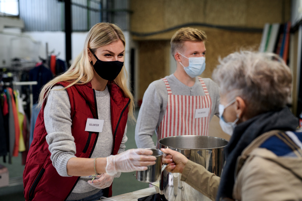 Volunteers serving hot soup for homeless in community charity donation by Jozef Polc on 500px.com