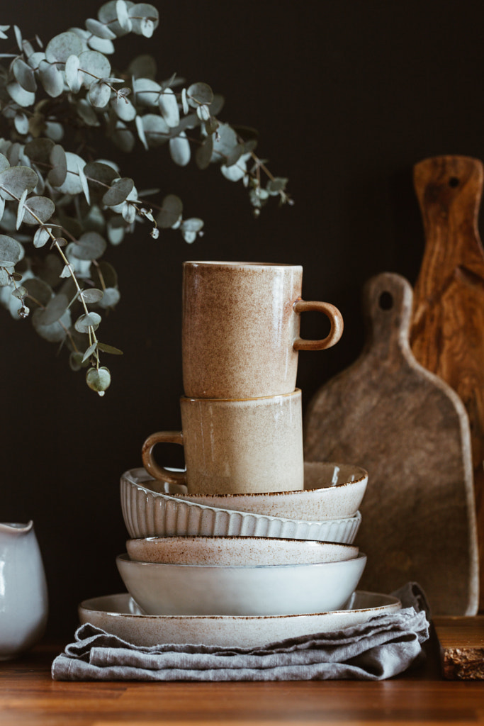 Set of kitchen ceramic tableware and wooden cutting boards on a table by Edalin Photography on 500px.com