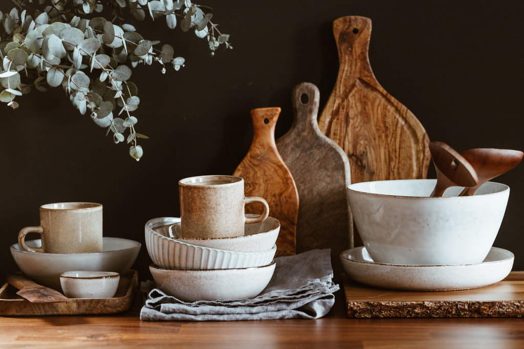 Set of kitchen ceramic tableware and wooden cutting boards on a table by Edalin Photography on 500px.com