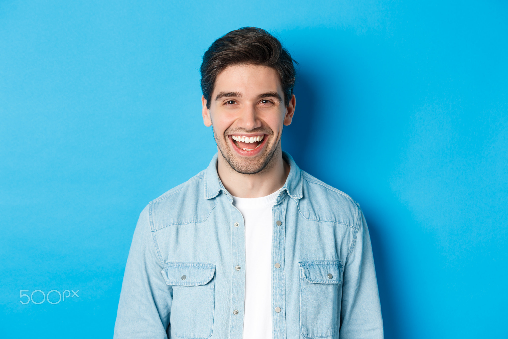 Close-up of handsome young man laughing, wearing casual clothes