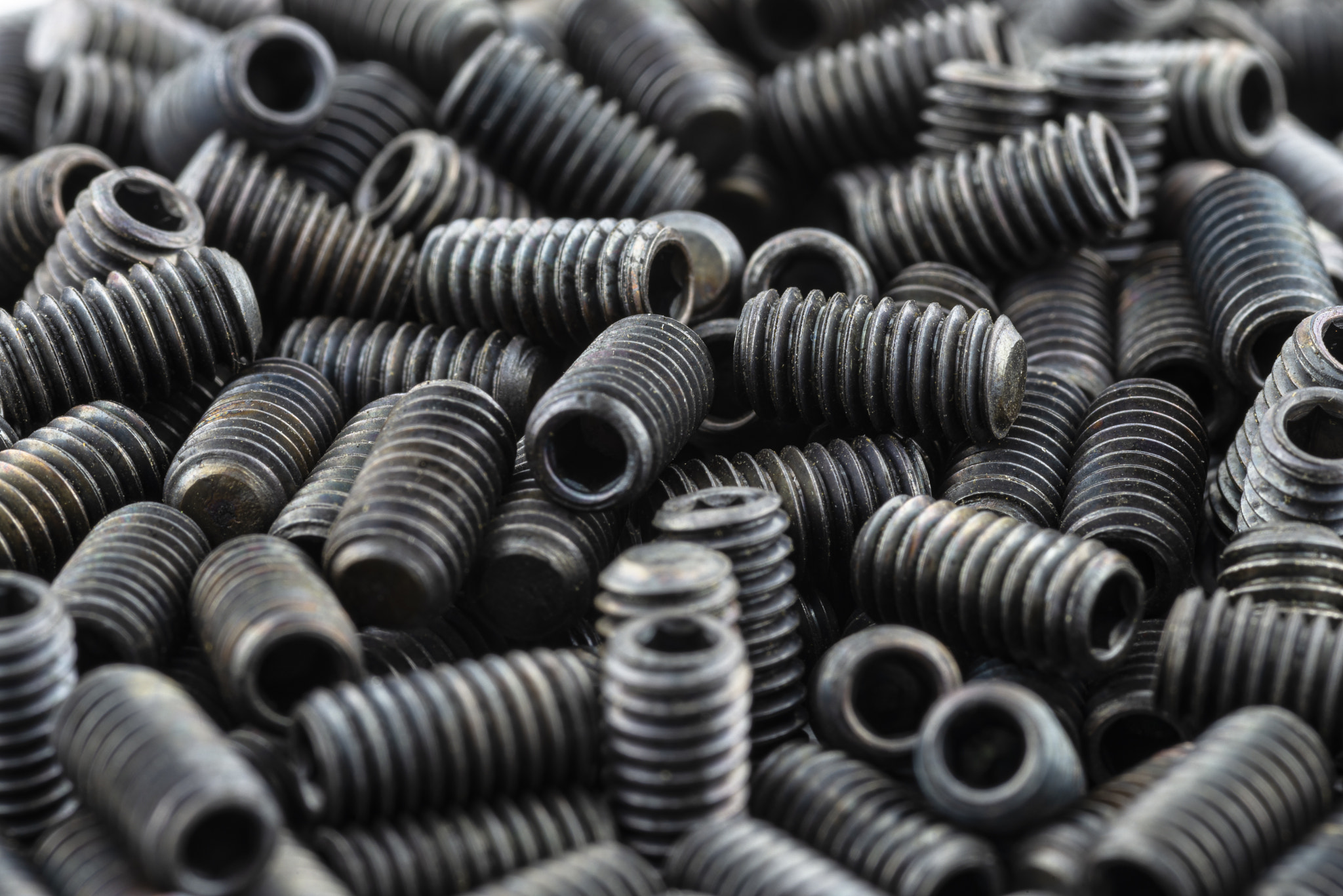 Background made from a macro shot of scattered, black grub screw.