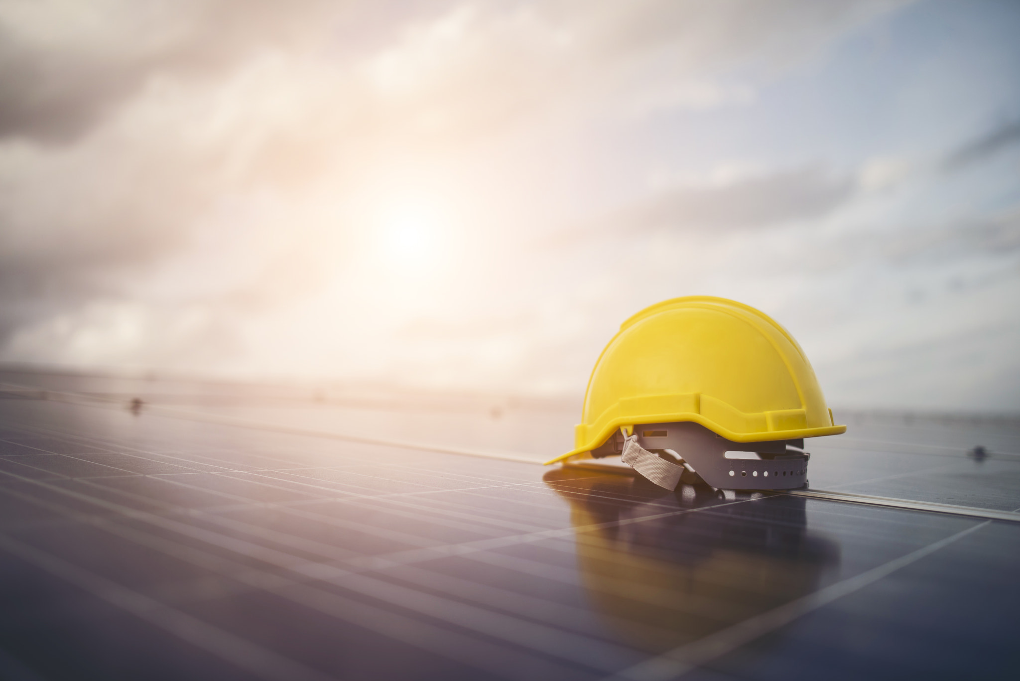 Yellow safety helmet on solar cell panel