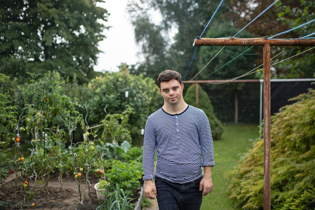 Down syndrome adult man walking outdoors in vegetable garden. by Jozef Polc on 500px.com