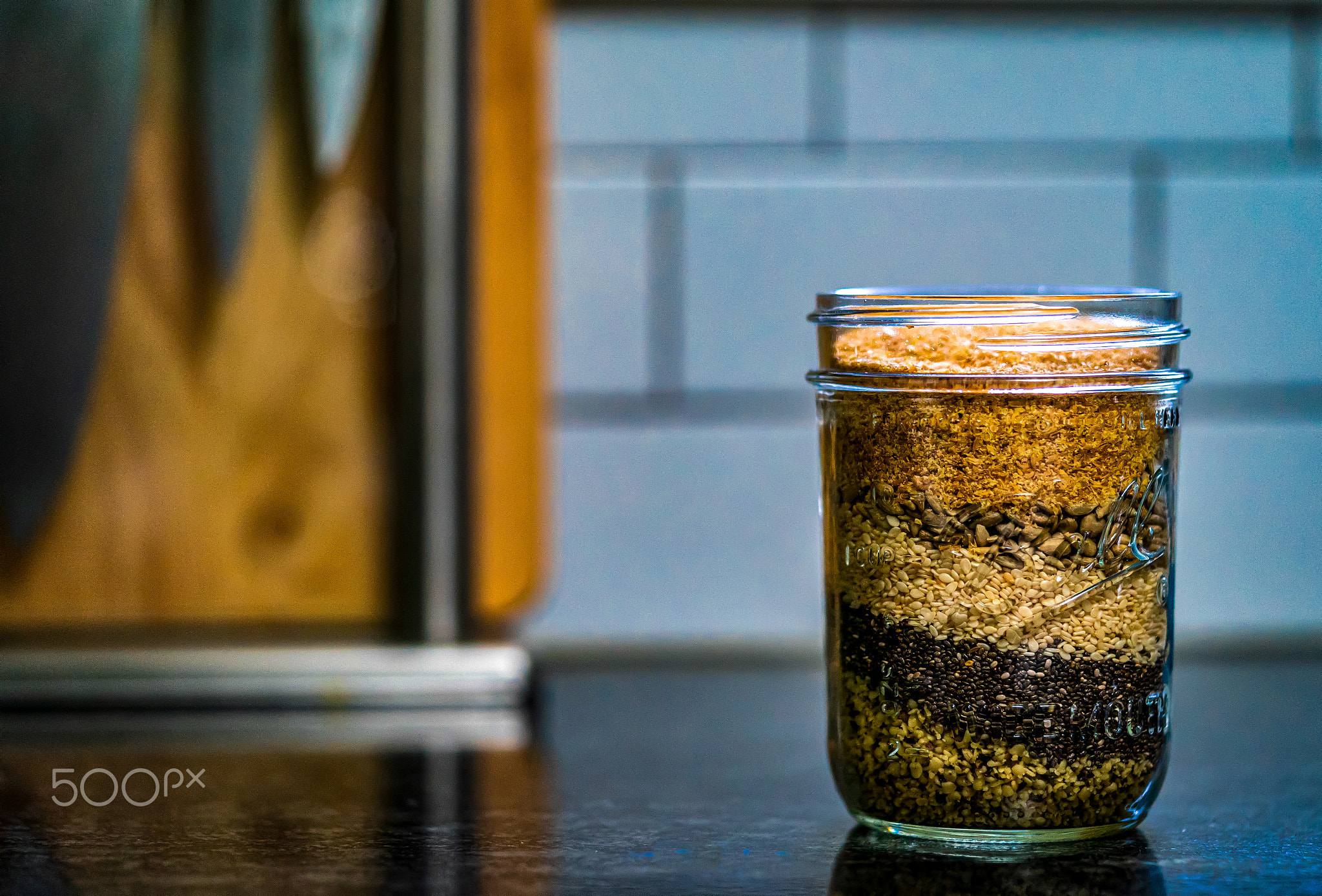 Jar of granola sitting on the kitchen counter.