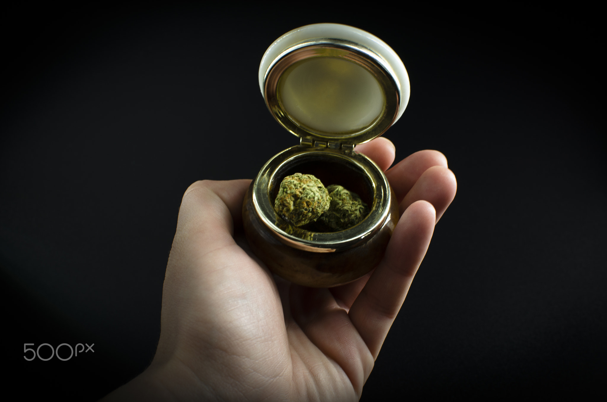 Weed. Cannabis Buds On A ceramic Jar Isolated Over Black Background