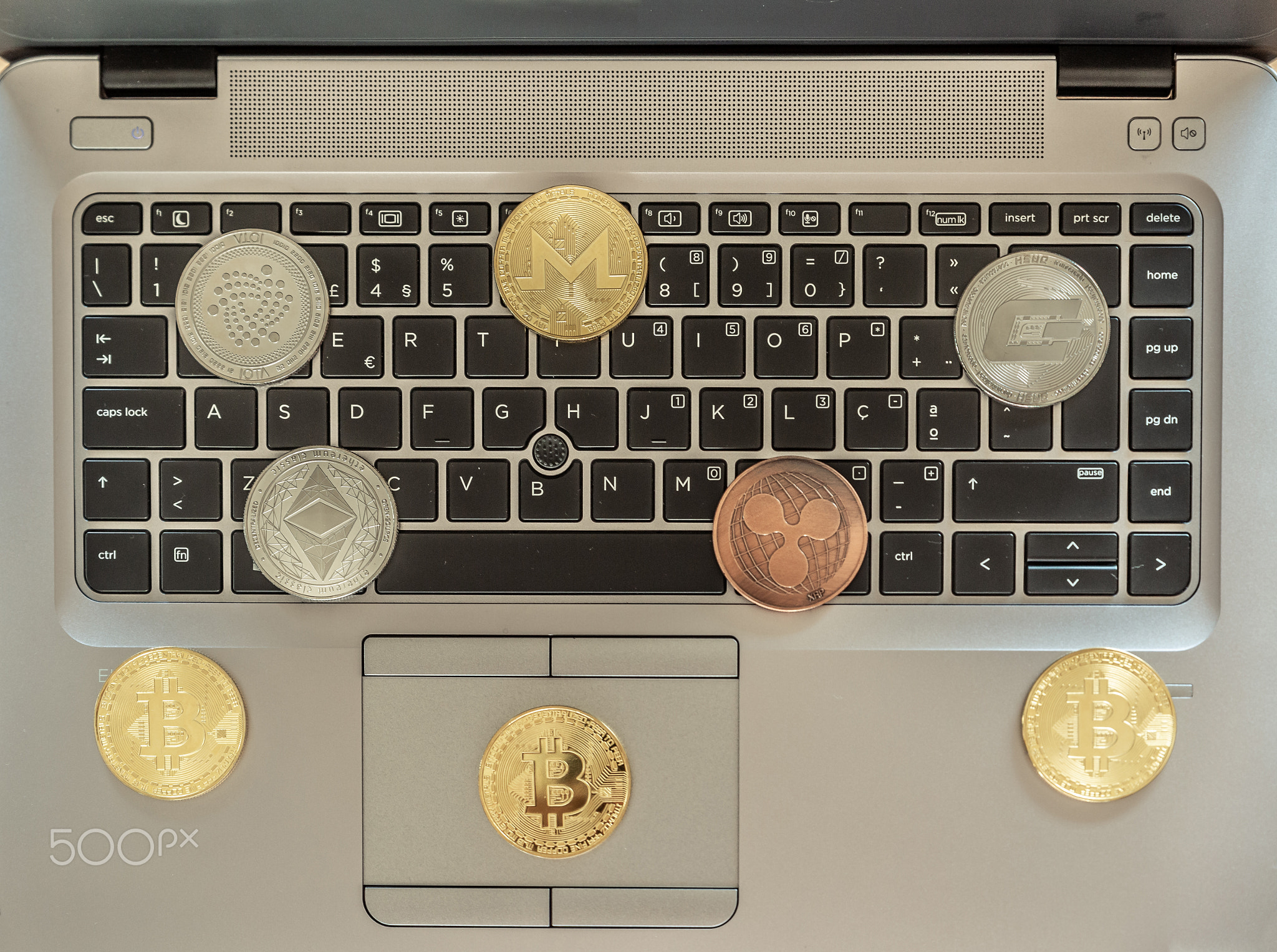 Laptop with several cryptocurrencies above the keyboard, bitcoin,