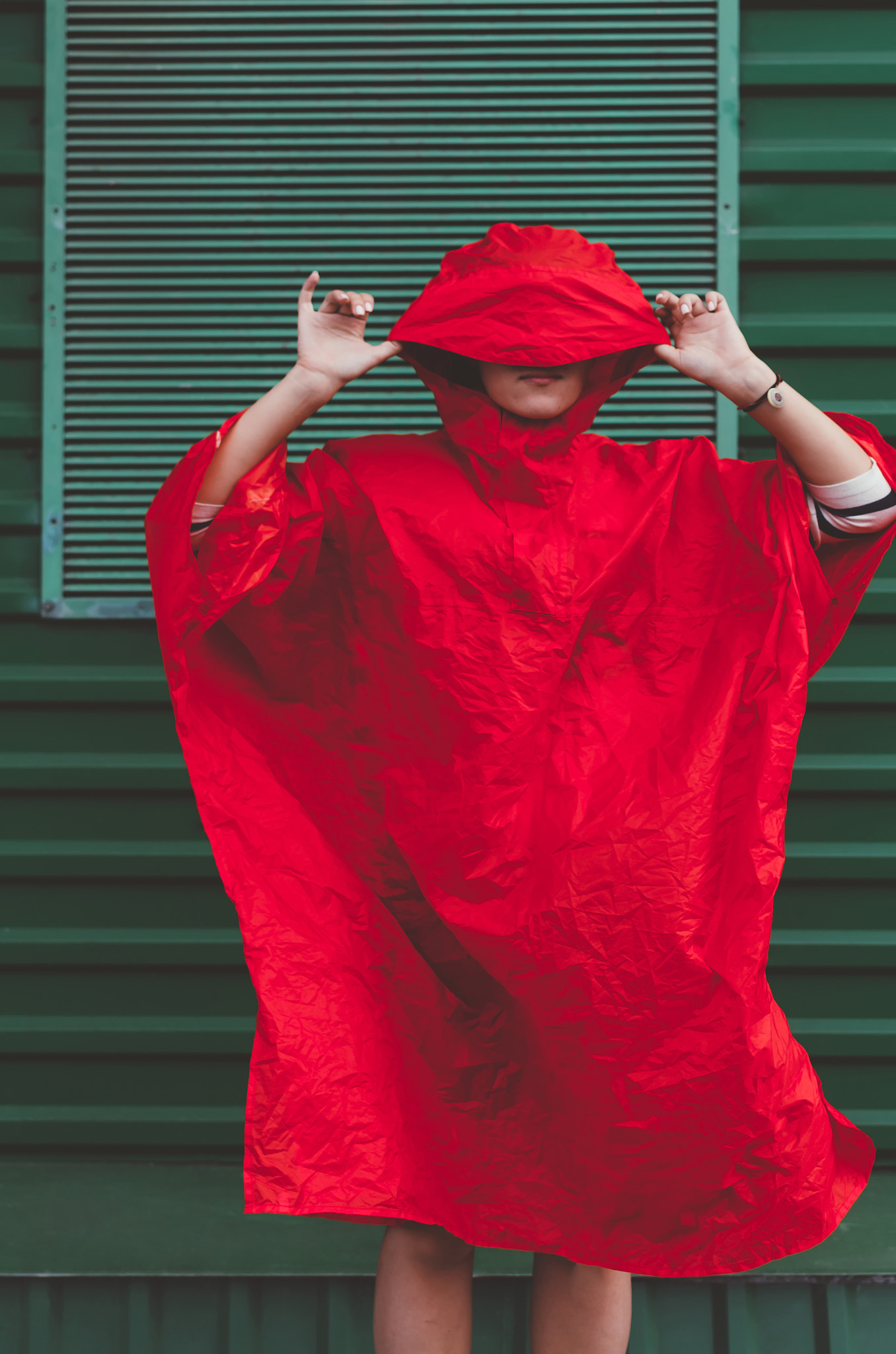 Cute positive short haired women in red rain coat