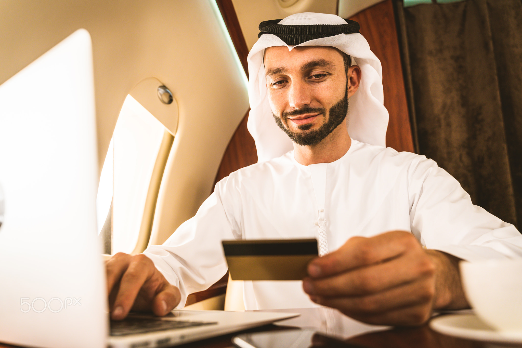 Arabian man wearing kandora flying on private jet