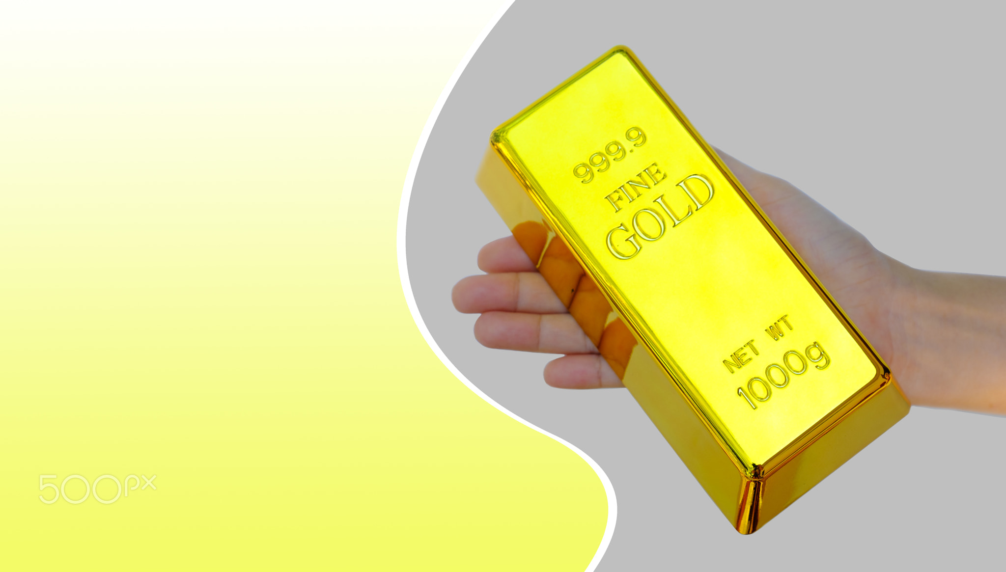 Human hand holding the gold bar on yellow and gray background