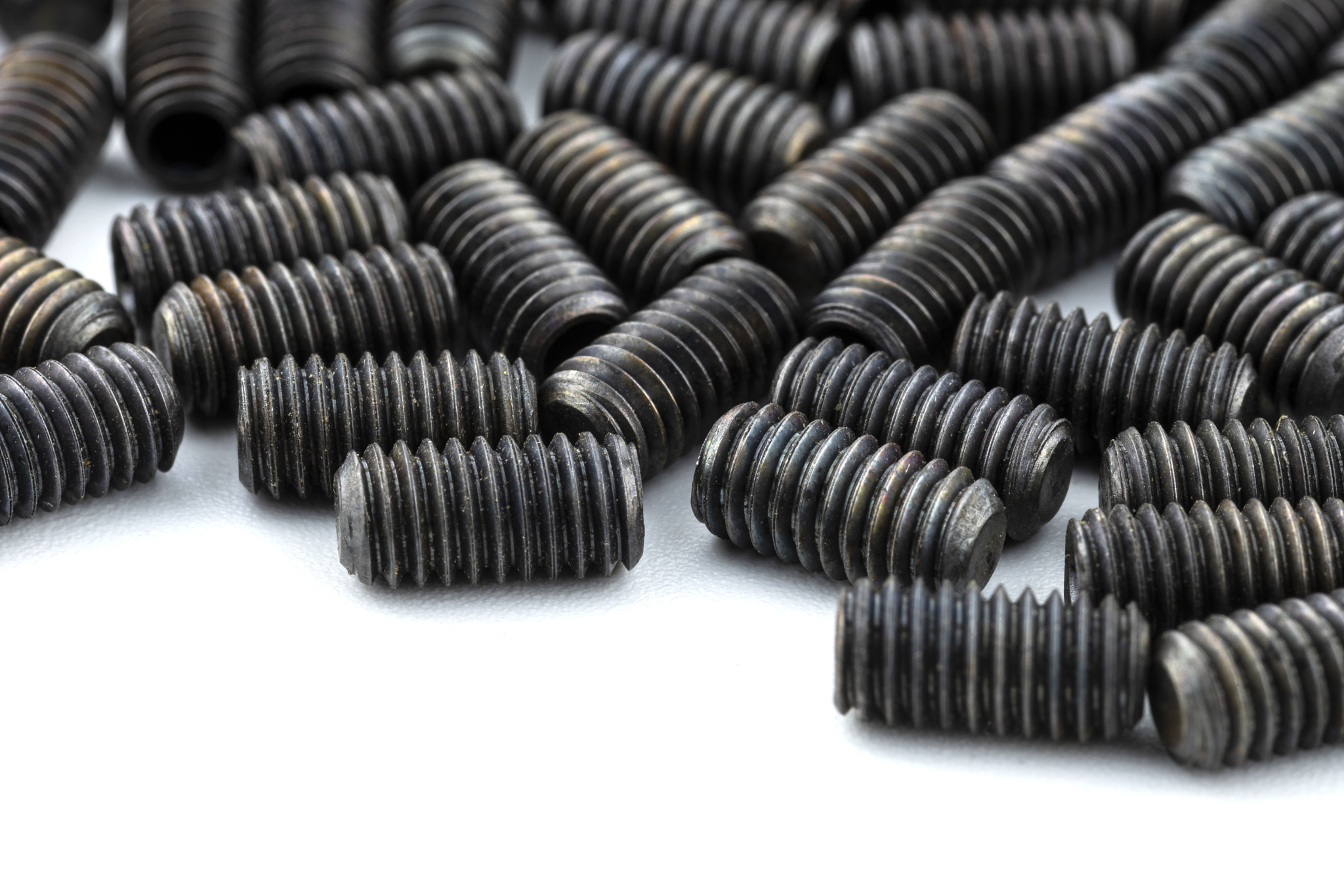Background made from a macro shot of scattered, black grub screw.