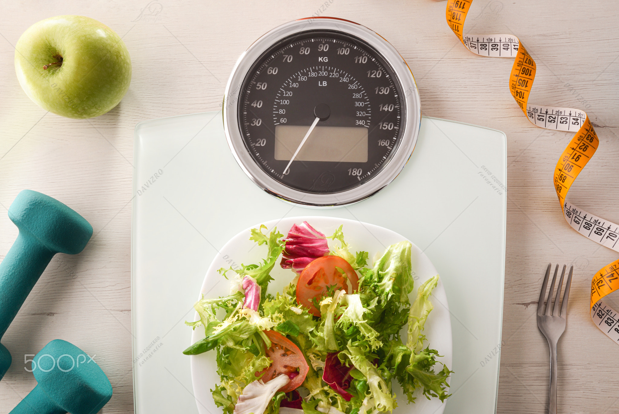 Weight control concept with salad cutlery and dumbbells