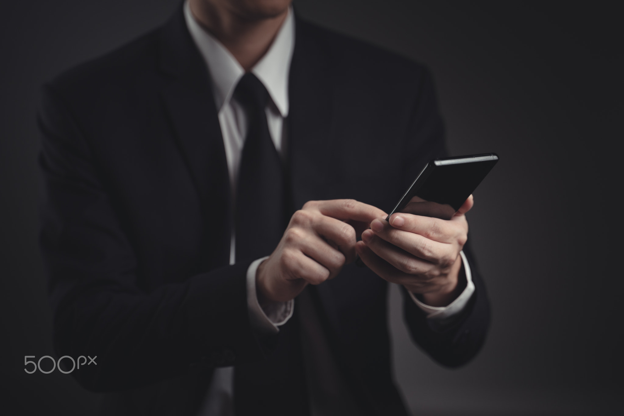 Hands typing message on smart phone.