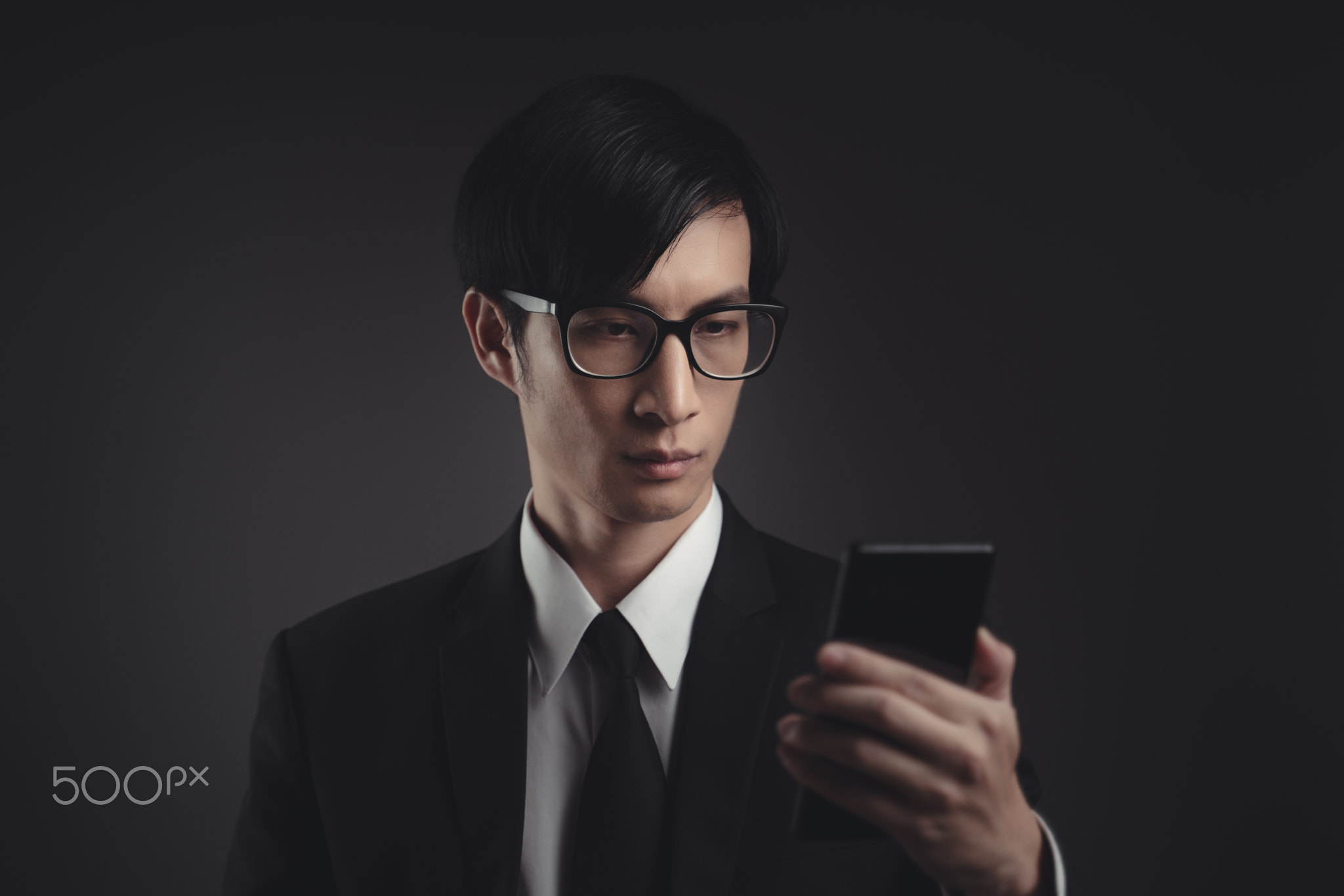 Businessman scans face by smart phone using facial recognition system.