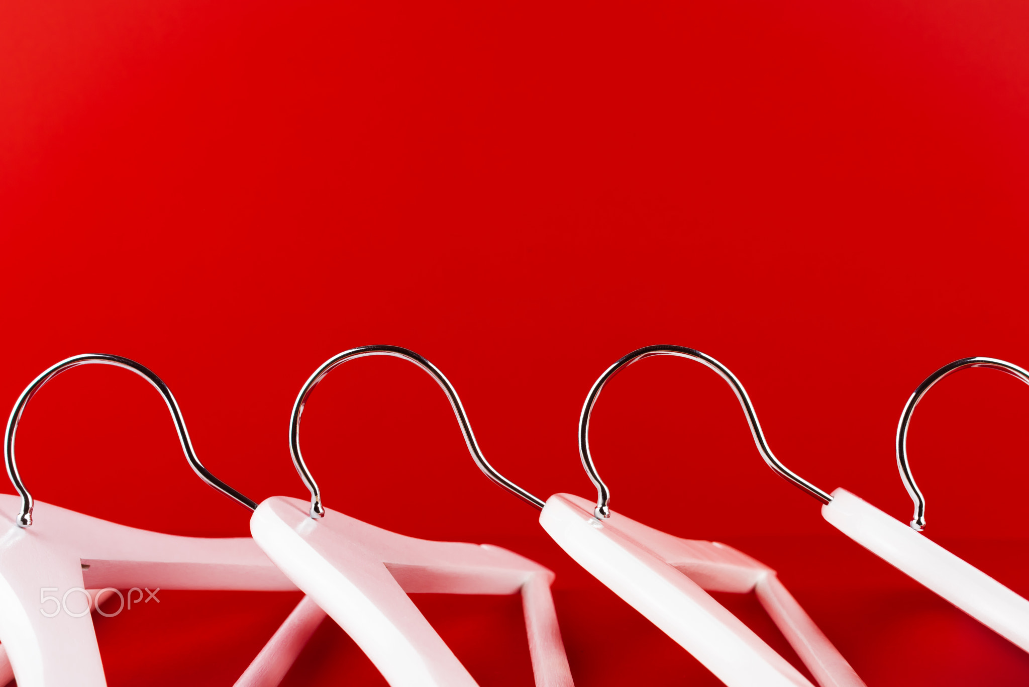 White hangers on a red background. Sales clothes concept.