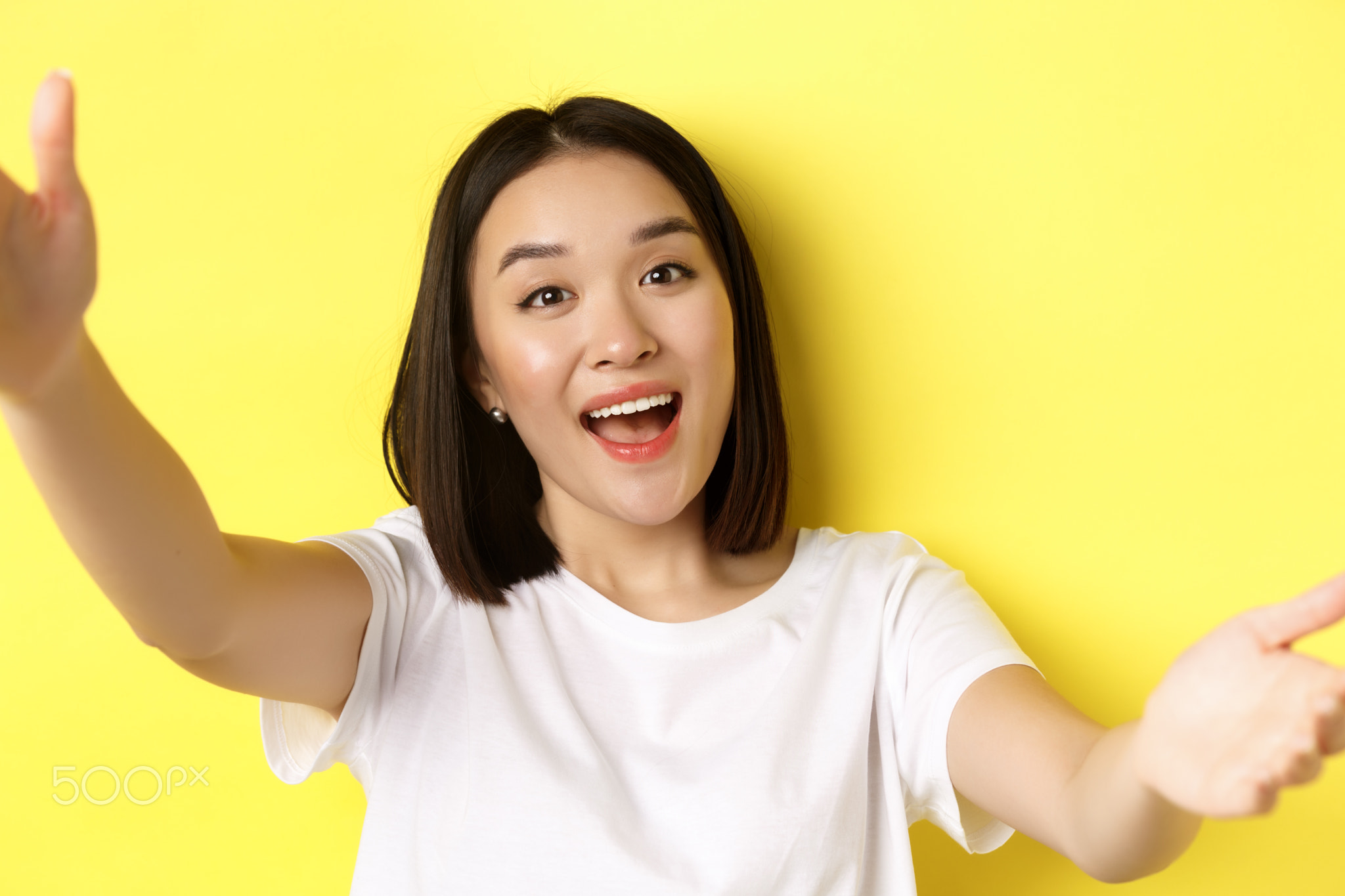 Image of beautiful asian woman holding smartphone camera and smiling