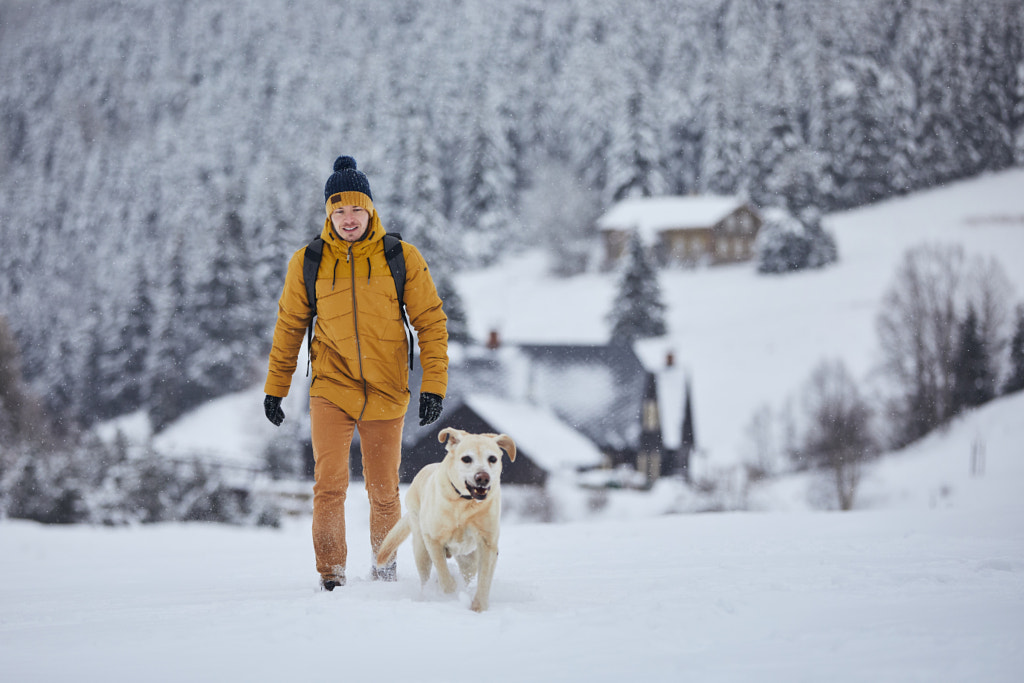  Man with pet dog strolling in snow versus old town in gorgeous nature by Jaromír Chalabala on 500px. com