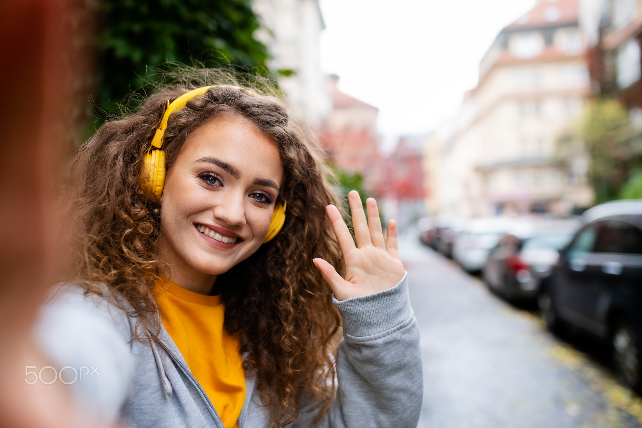 Young woman with smartphone outdoors on street, video for social media