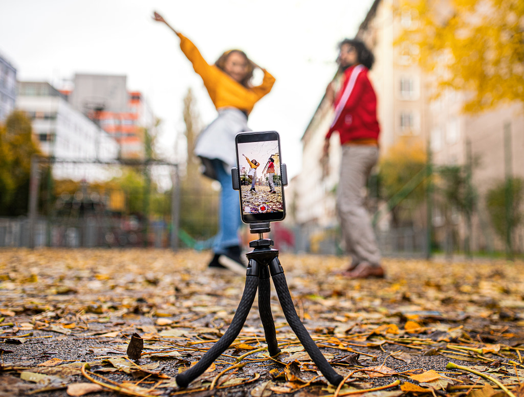 Young couple with smartphone making video for social media outdoors in by Jozef Polc on 500px.com