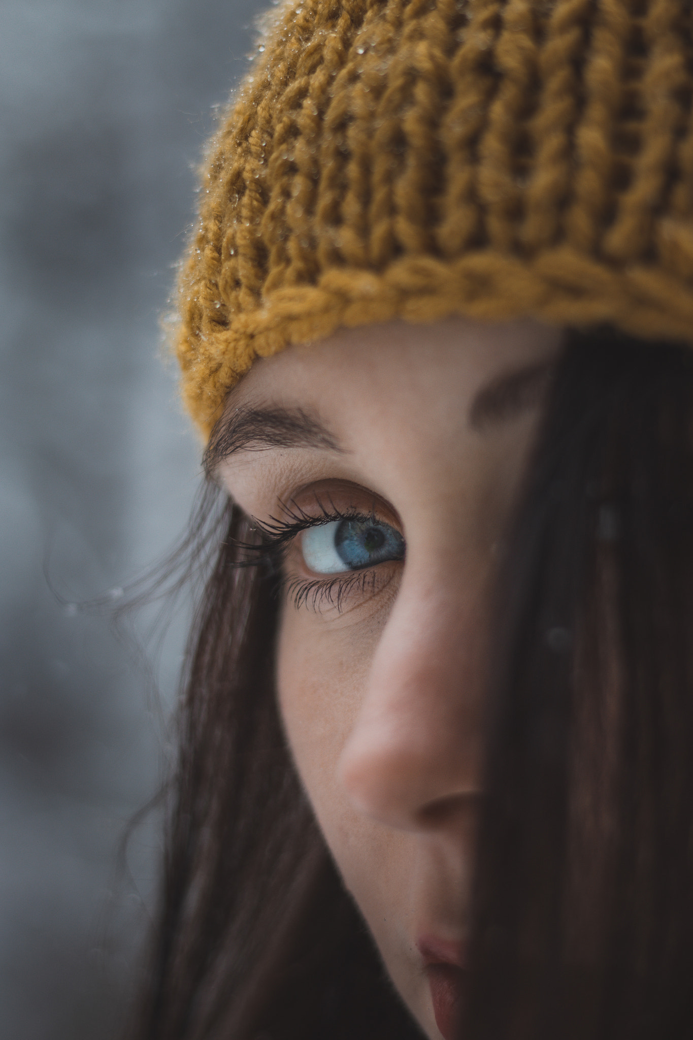 Blue and green eye of a young girl aged 20-24 when falling snow.