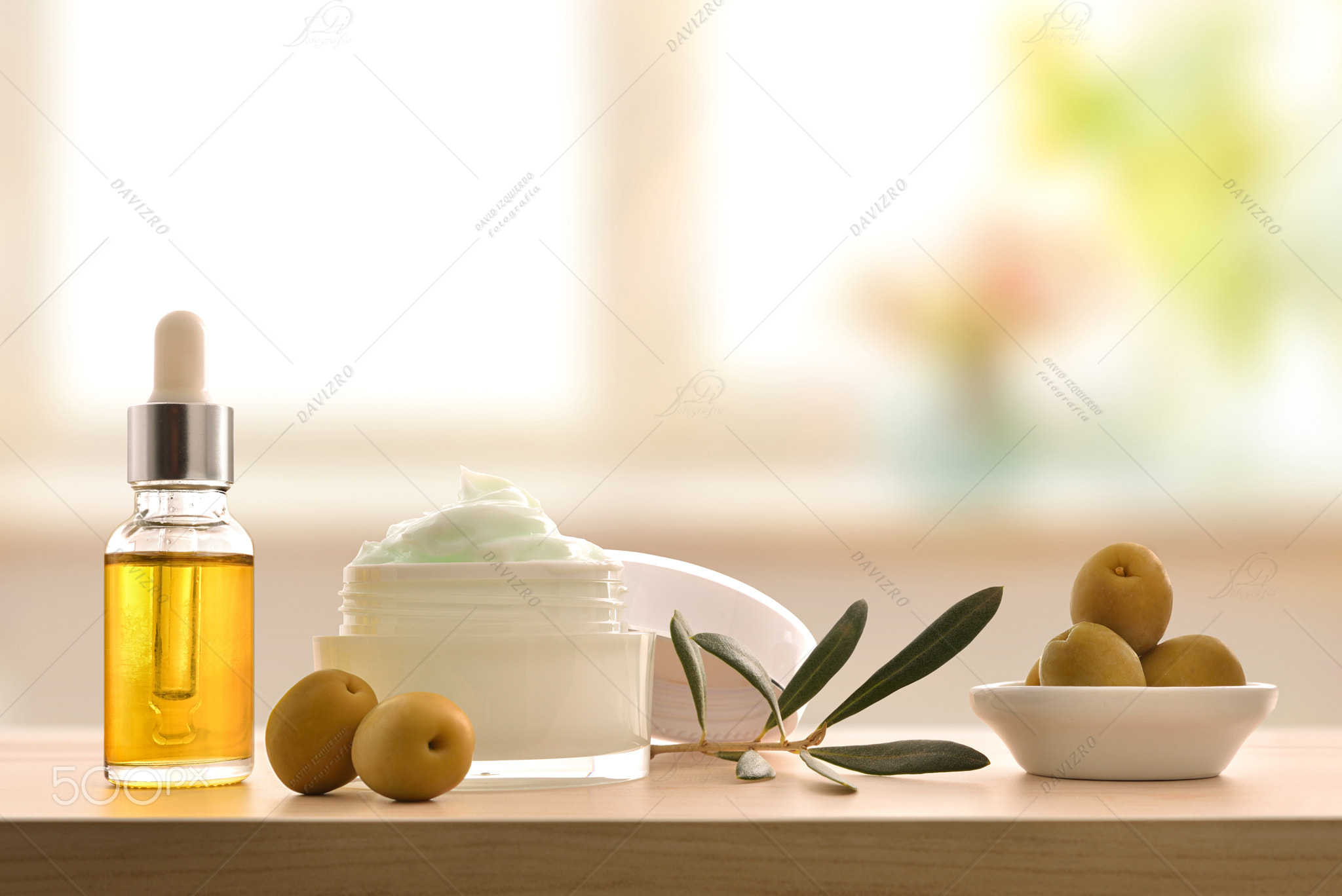 Olive moisturizing cream and serum on wood table front
