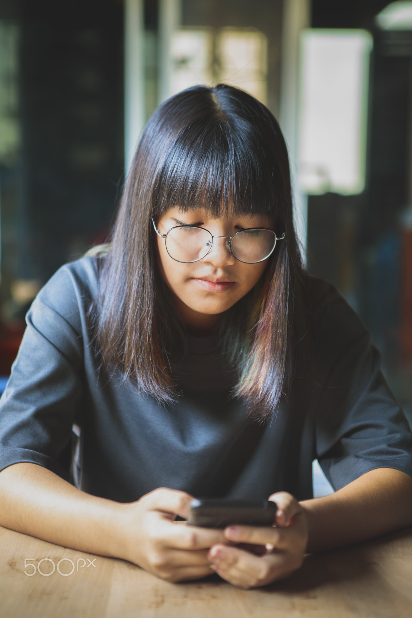 asian teenager holding smart phone in hand