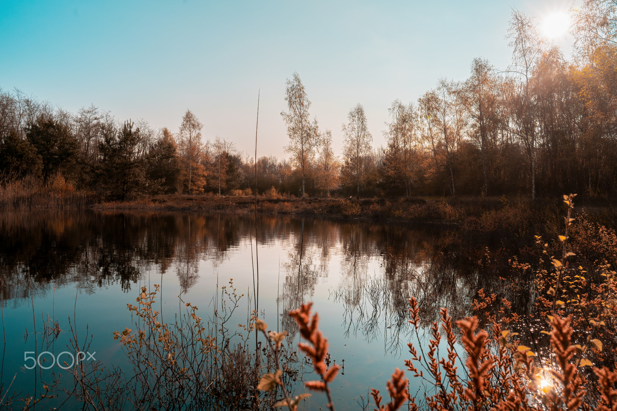 Sun in colorful mood on a lake with reflections on the water