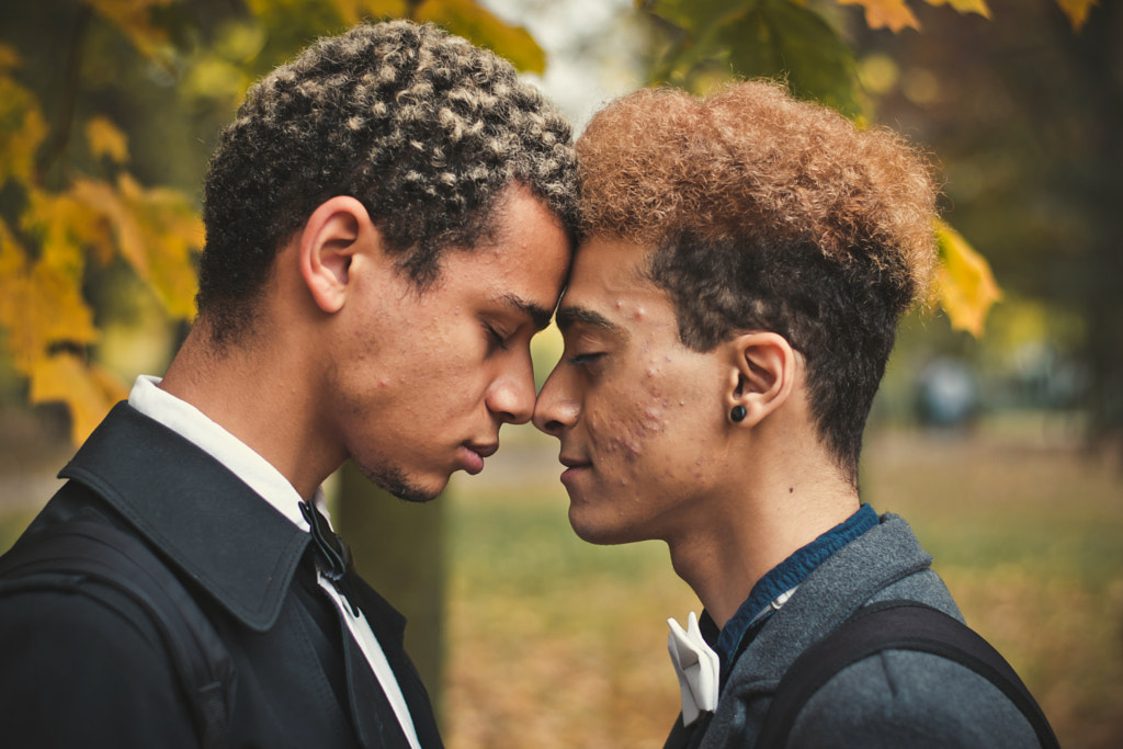 Handsome young gay couple standing head to head in park during autumn by Viktor Makhnov on 500px.com