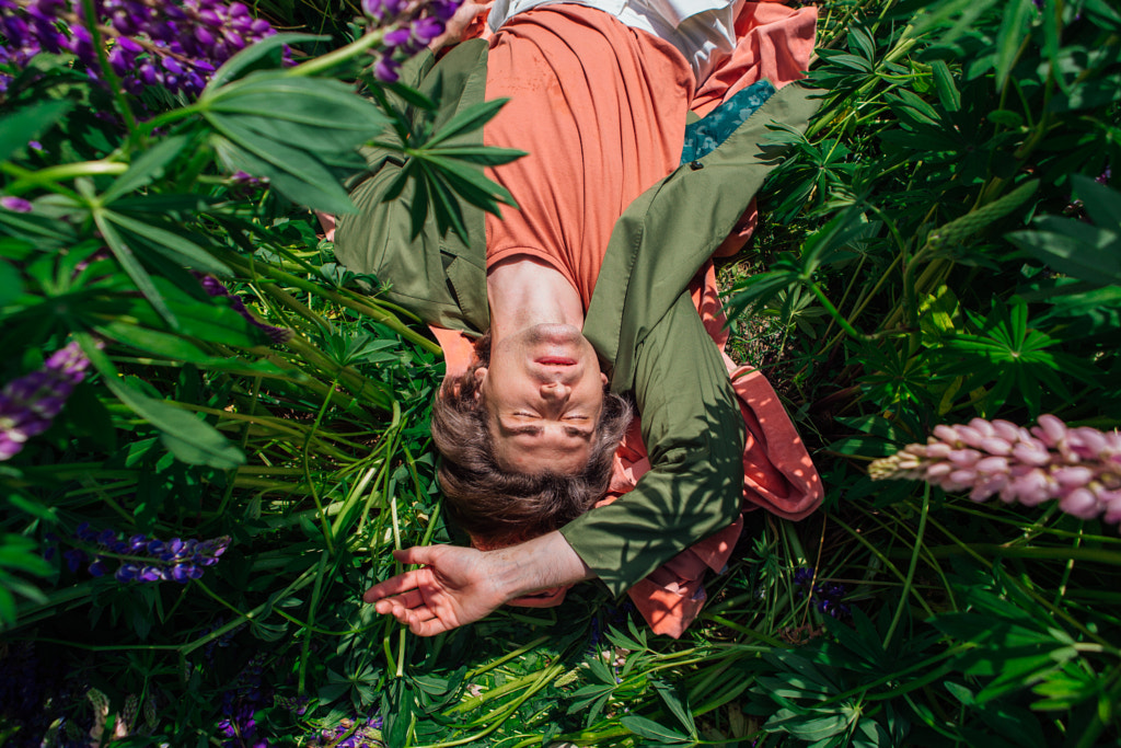 Young handsome man lies in lupins by Elena Yurkina on 500px.com