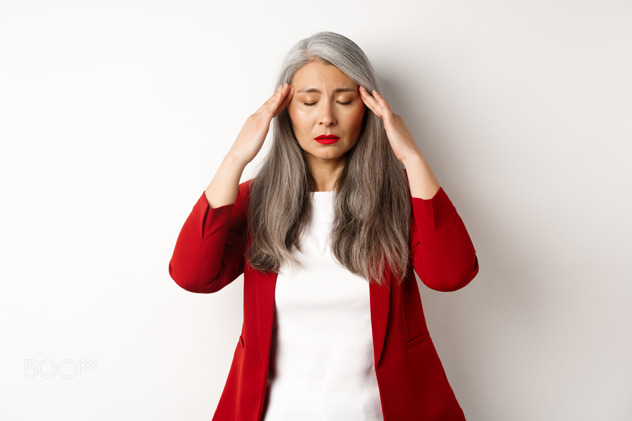 Distressed asian businesswoman trying to calm down, massaging temples